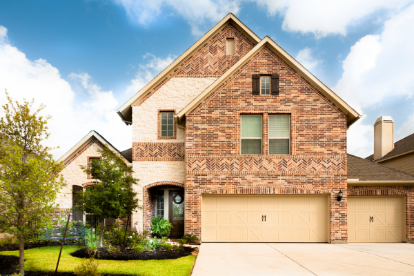 Brick house exterior with freshly washed driveway and garage