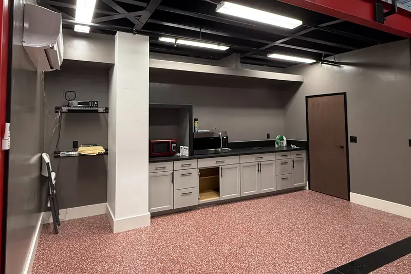 Owner-built kitchenette with cabinets and a restroom door