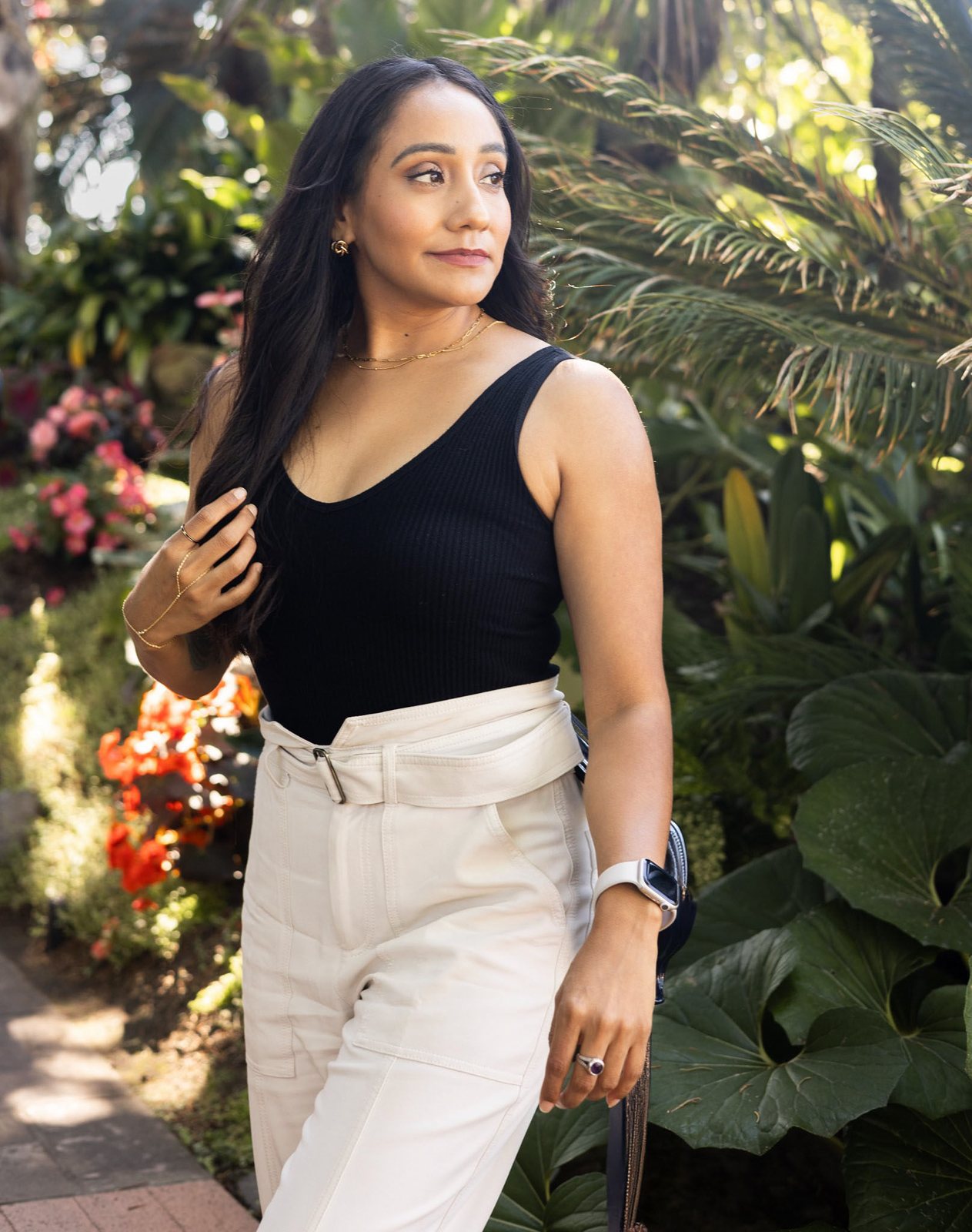 Andrea Arroyo in a garden, looking over her shoulder