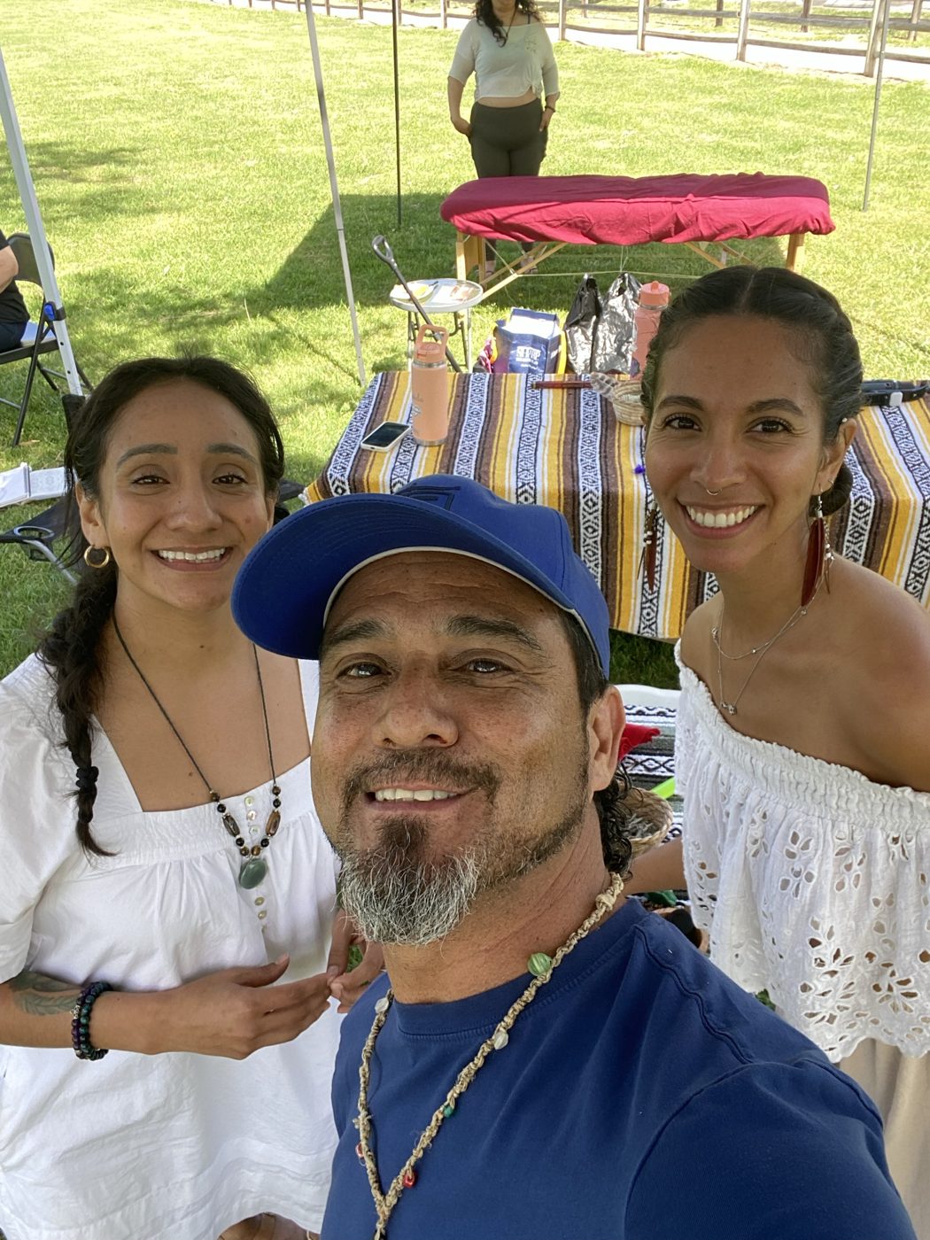 Andrea smiling with fellow practitioners at an outdoor community limpia