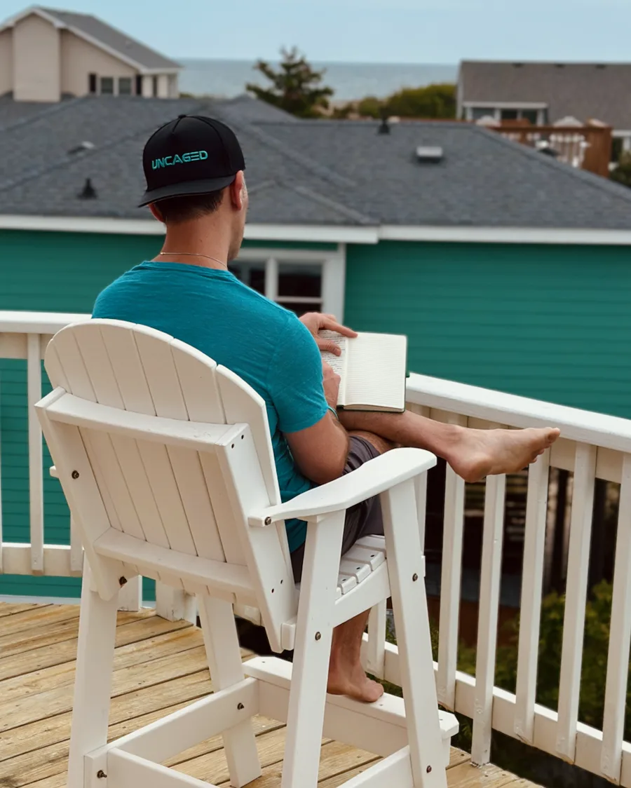 Matt Doan journaling on a deck by the beach