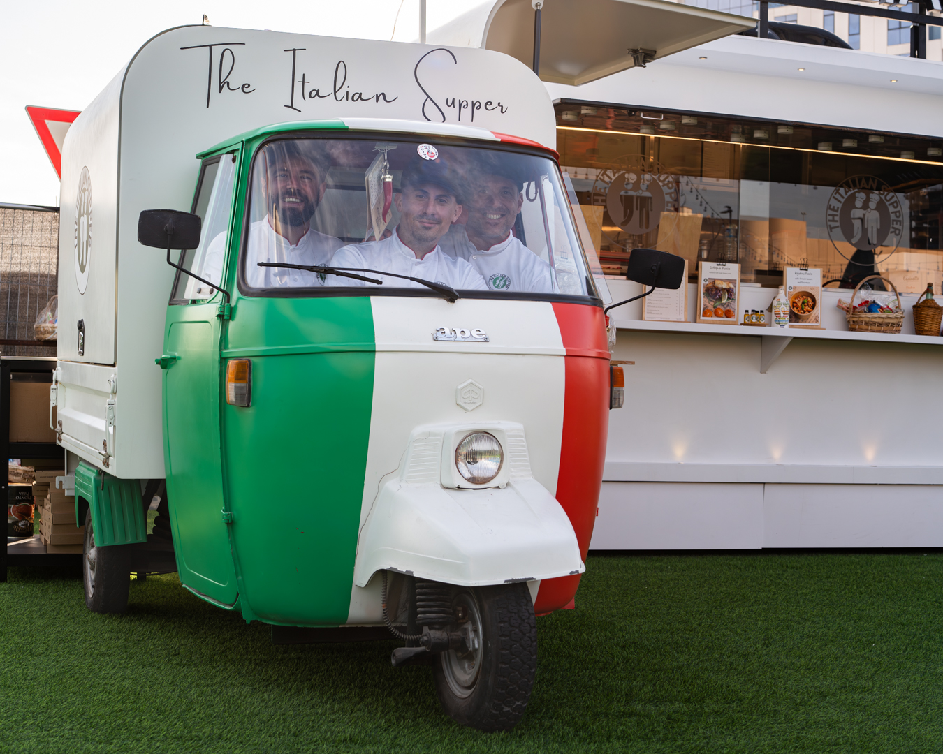 The Italian Supper team inside their iconic Italian food truck decorated with the tricolore, serving authentic pizza and pasta in Jumeirah Village Circle, Dubai.