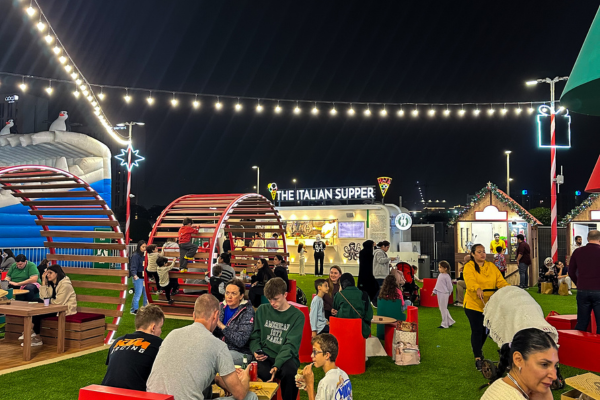 The Italian Supper team inside their iconic Italian food truck decorated with the tricolore, serving authentic pizza and pasta in Jumeirah Village Circle, Dubai.