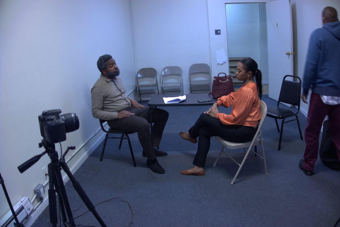 Rehearsal setup with camera and seated actors