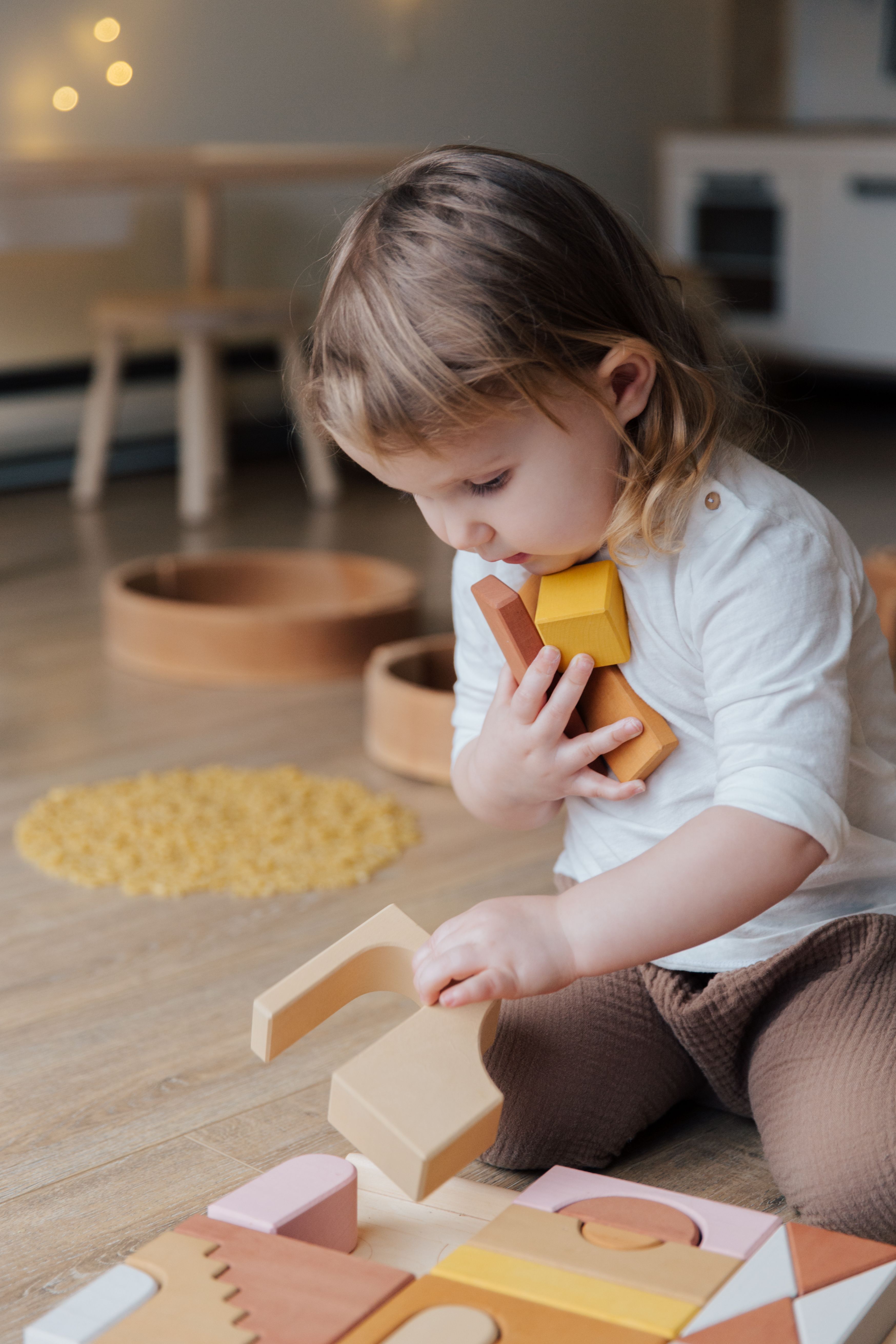 Toddler absorbed in wooden block play