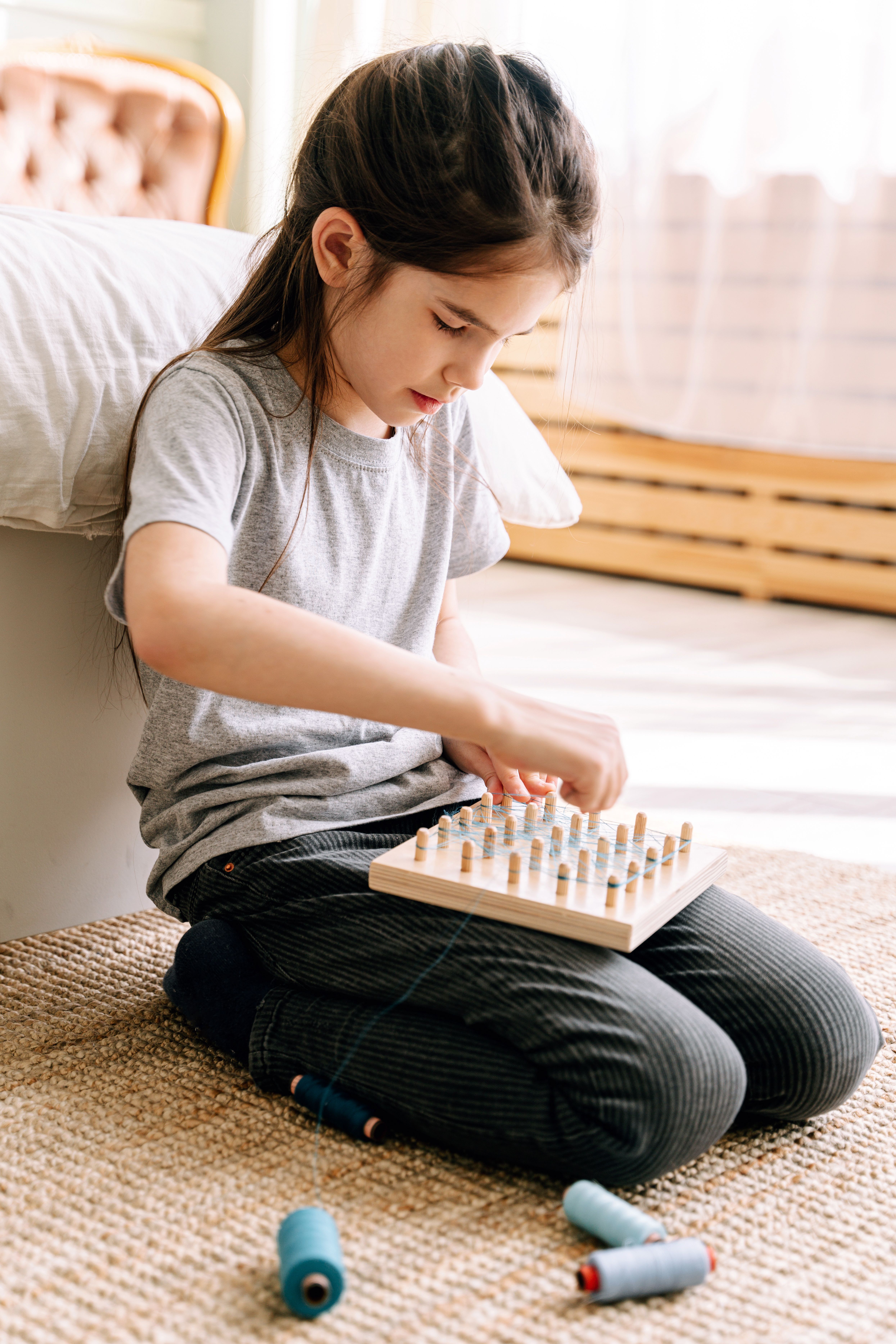 Older child sitting on the floor absorbed in a hands-on activity