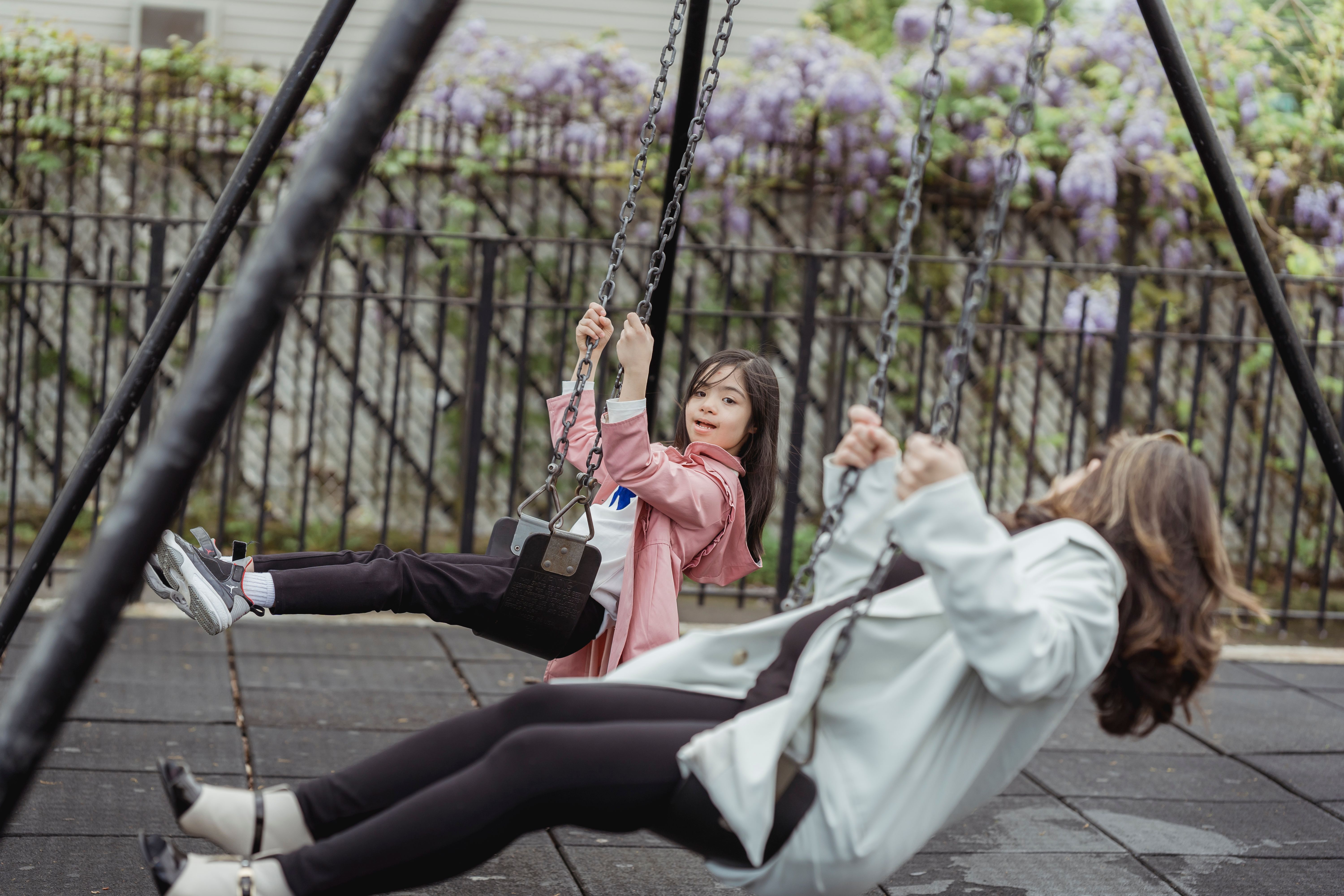 Parent and child swinging together at a playground