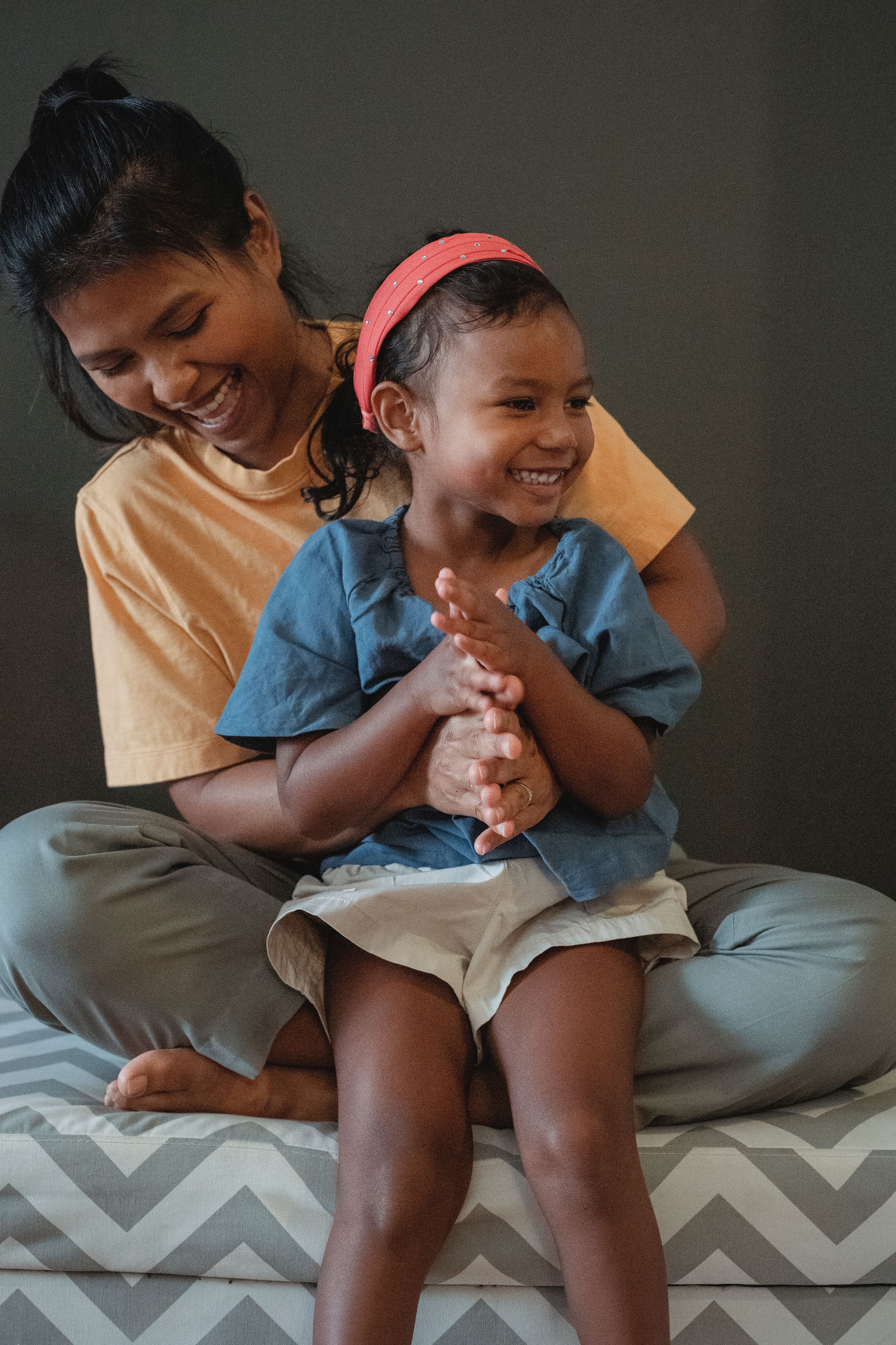 Parent and child clapping together, both laughing