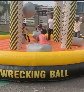 4k hyper realistic image Children running on green grass near a colorful inflatable slide with parents watching from benches 4k hyper realistic image Children running on green grass near a colorful inflatable slide with parents watching from benches