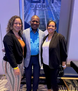 Lee Moultrie standing with two professional partners at a business event.