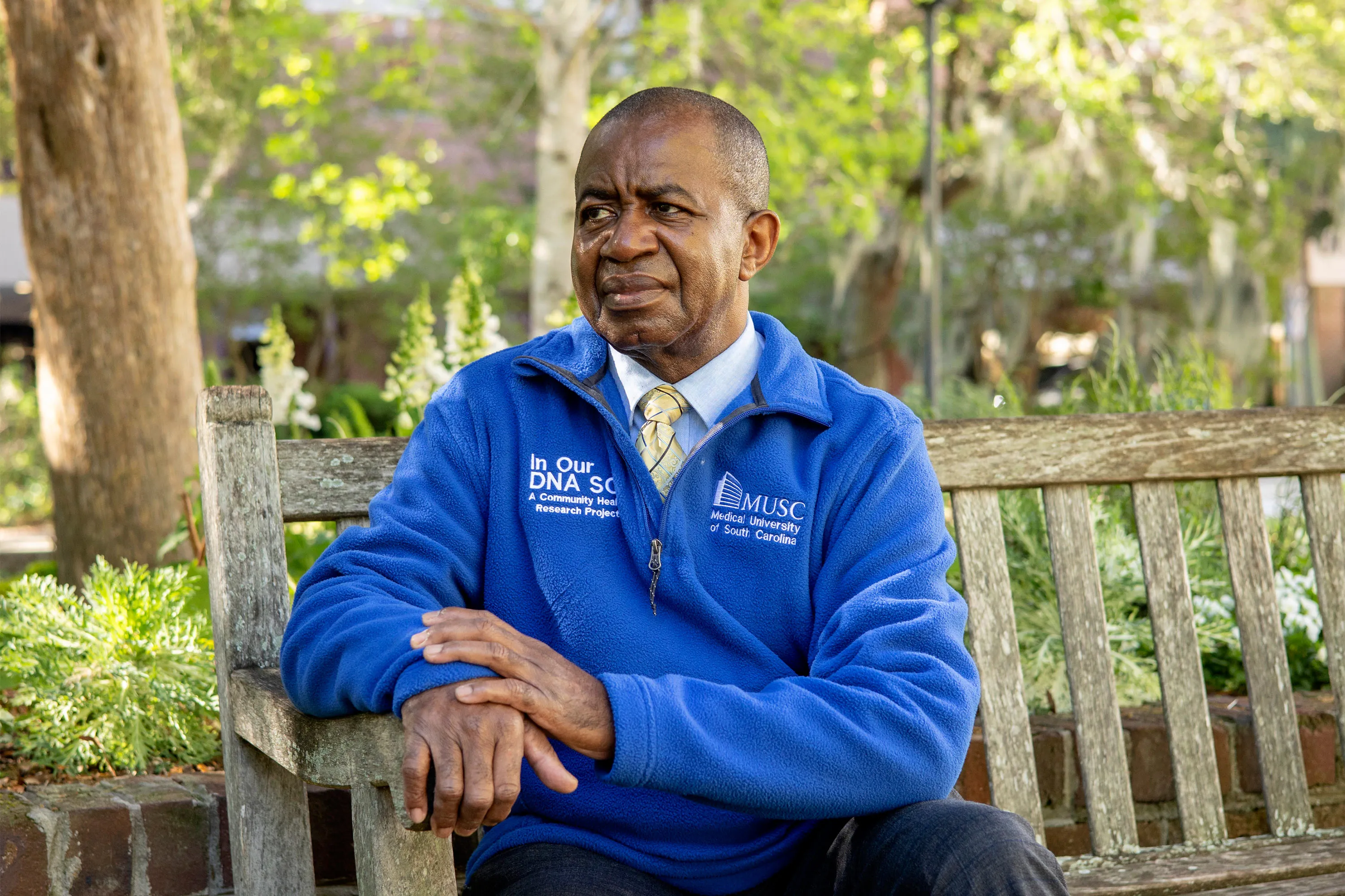 Lee Moultrie seated outdoors wearing an In Our DNA SC and MUSC pullover.
