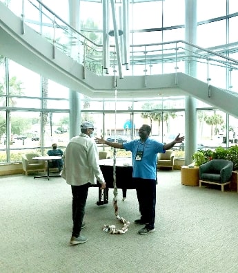Lee Moultrie speaking with another person inside a healthcare facility.