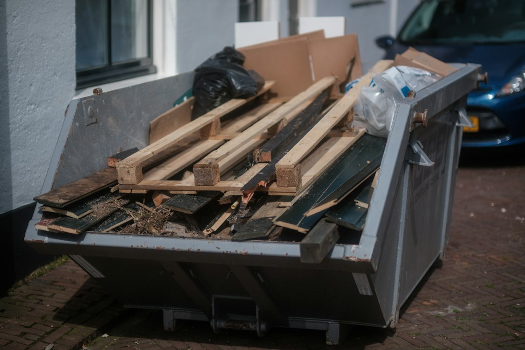 A roll-off disposal container loaded with scrap wood, cardboard, and trash bags for Toronto junk removal.