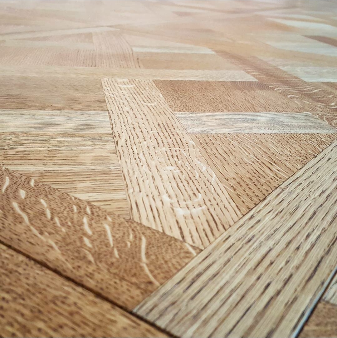 Close-up of a beautifully refinished hardwood floor showcasing intricate patterns and natural wood grain, highlighting the expert restoration services by AZ Floor Haven.