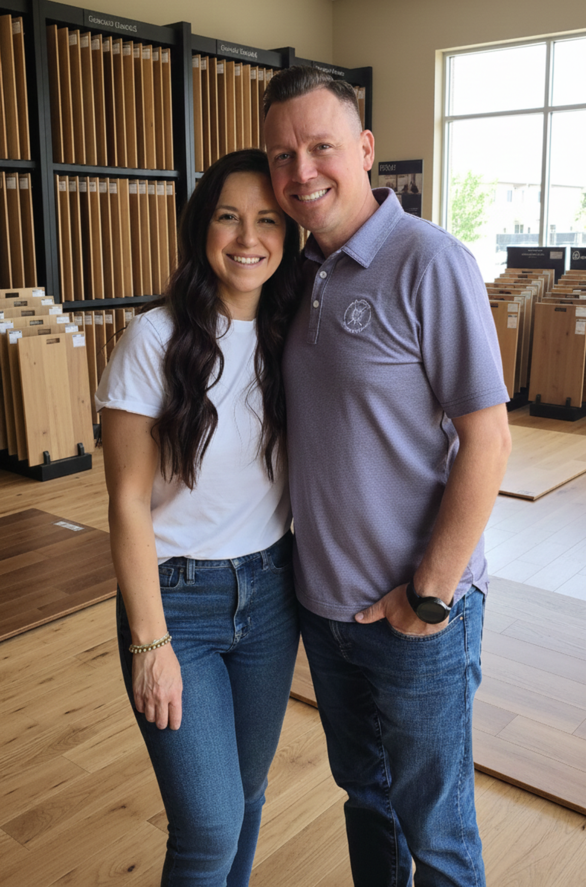 Ryan and Jenna from AZ Floor Haven smiling together in a flooring showroom, showcasing wood flooring samples in the background, representing AZ Floor Haven's personalized flooring services.