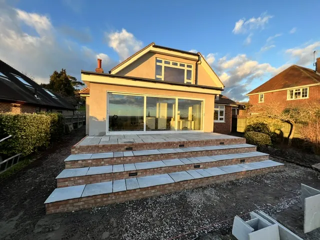 Wide patio steps with brick risers at the back of a house