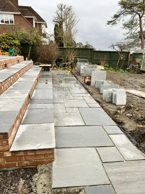 Paved patio and steps along the back of a house