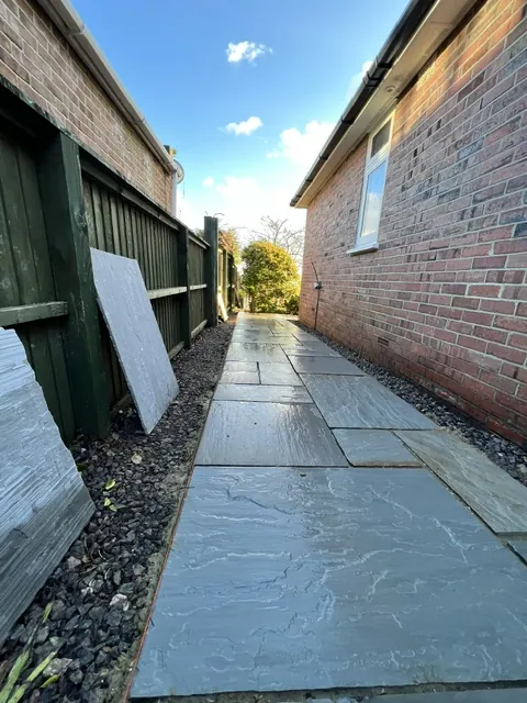 Paved side path running along a brick wall
