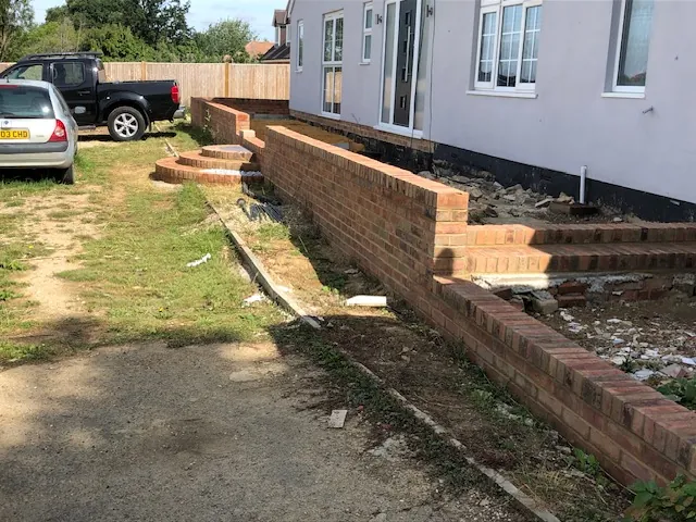 Brick garden walls and steps along a house