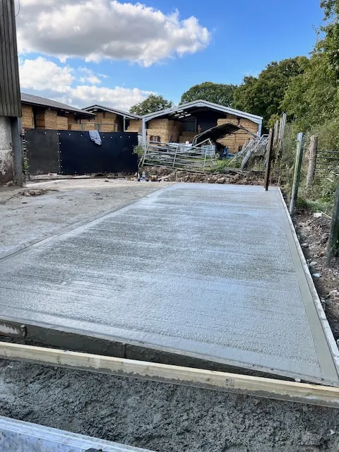 Finished concrete base next to farm buildings