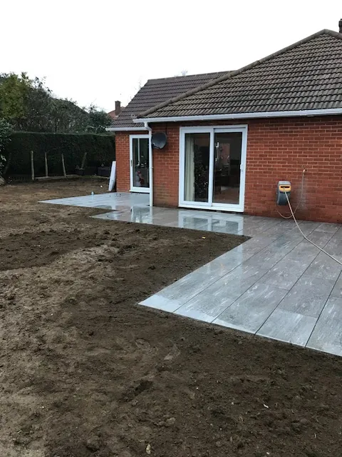 Light paved path and patio leading to a bungalow