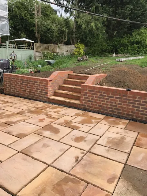 Paved patio with brick retaining walls and steps