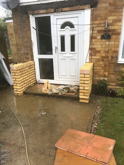 Low buff-brick walls beside a front door