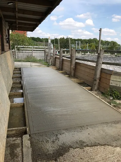 Long concrete path beside a timber outbuilding