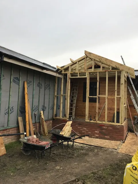 Timber frame going up on a brick base