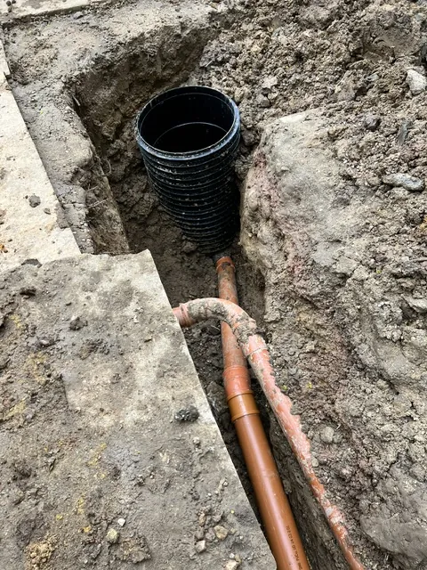 Inspection chamber and pipework in a trench beside a house