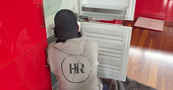 Technician repairing an in-home appliance