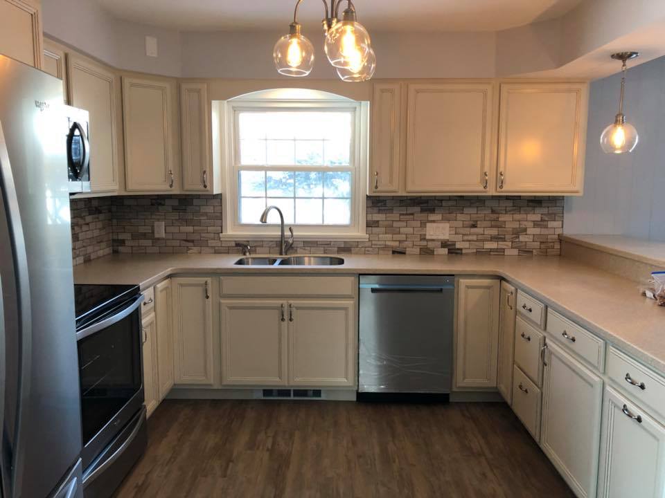 Kitchen Remodeling — Cream cabinets, stone mosaic backsplash, globe pendants