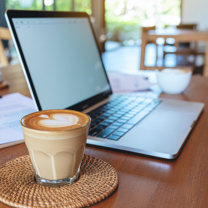Laptop and coffee set up in a coffee shop