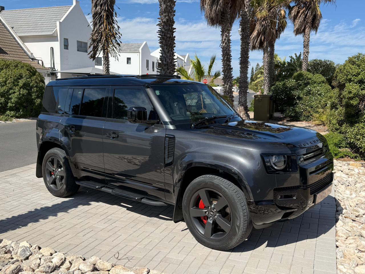 Gun metal grey 2023 Land Rover Defender X parked outdoors.