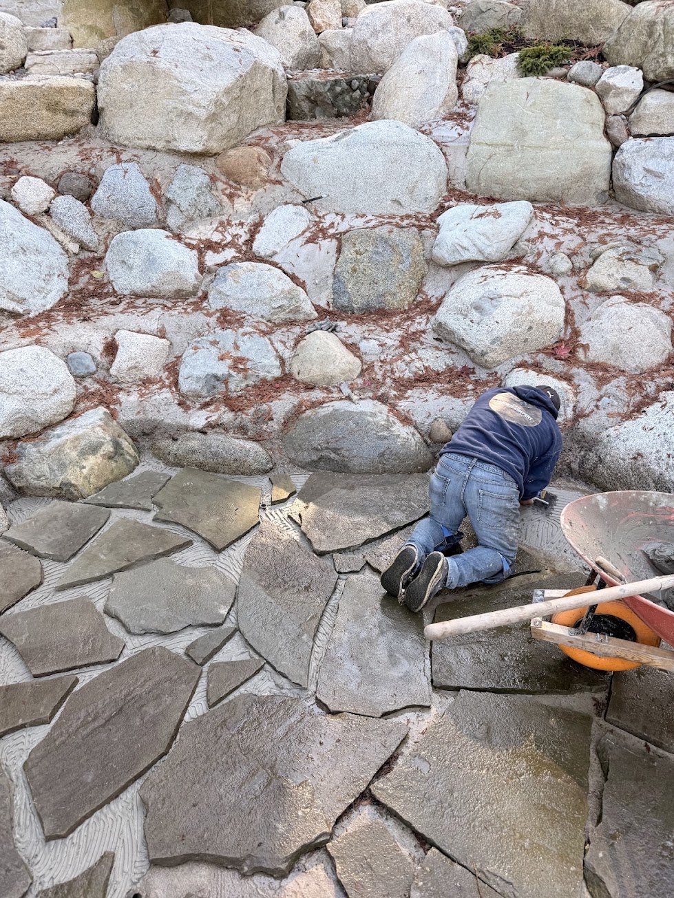Setting natural slate into the bottom of a backyard rock pool in Surrey BC