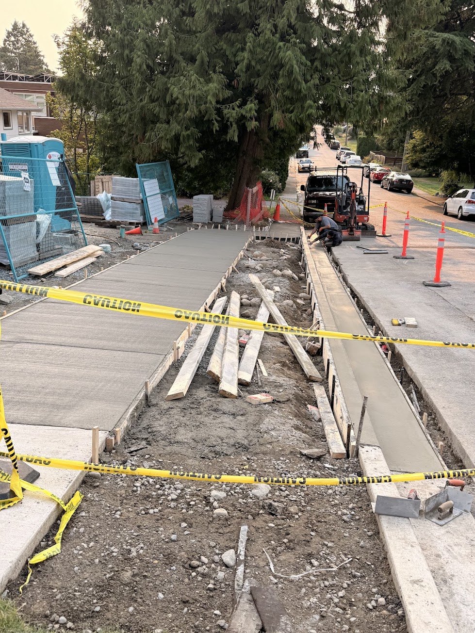 Crew finishing the curb and gutter on a new City sidewalk in the City of North Vancouver
