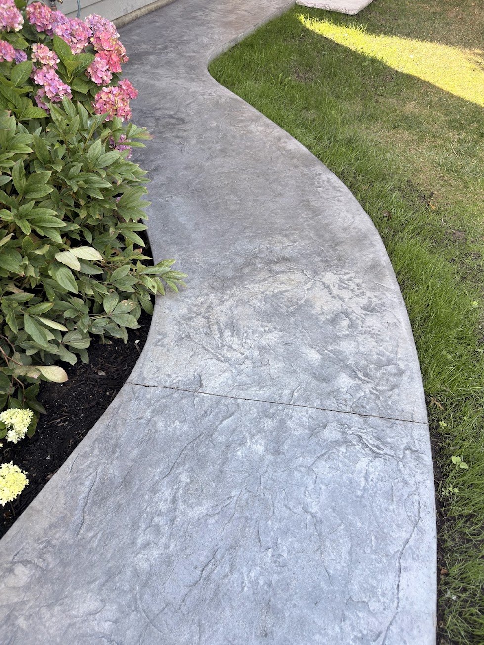 Curved stamped concrete walkway with a stone texture in Steveston, Richmond BC