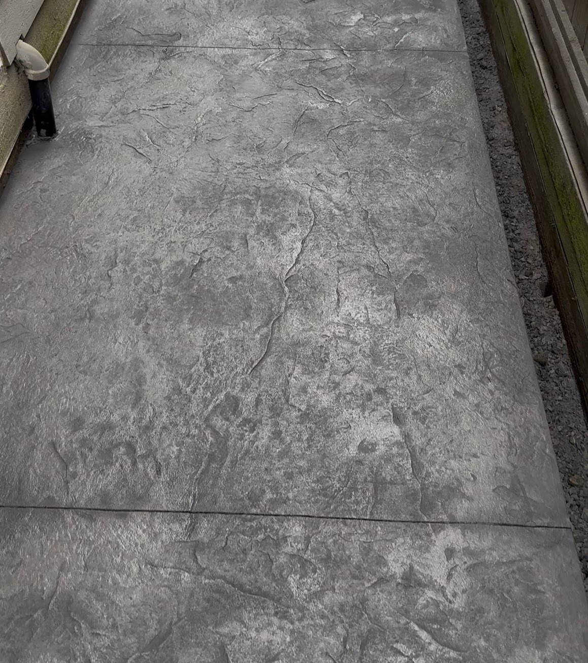 Close-up of a stone-texture stamped concrete finish on a side yard walkway in Steveston, Richmond BC