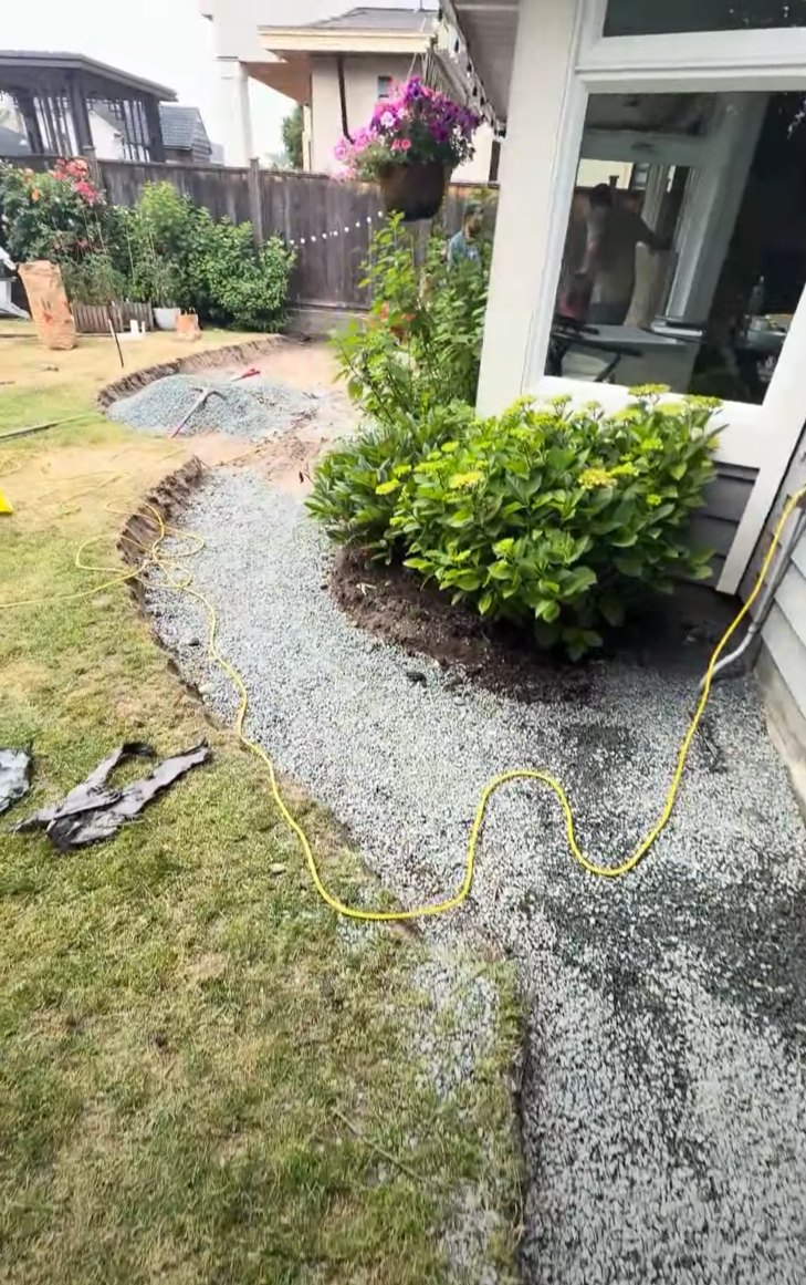 Gravel base placed on a curved concrete walkway before forming in Steveston, Richmond BC