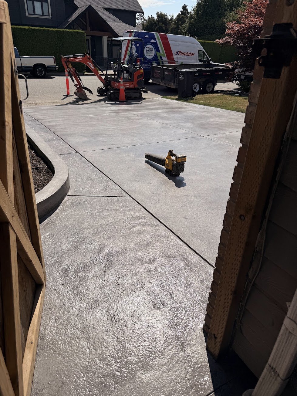Smooth-finish coloured concrete driveway with a stamped border in Steveston, Richmond BC