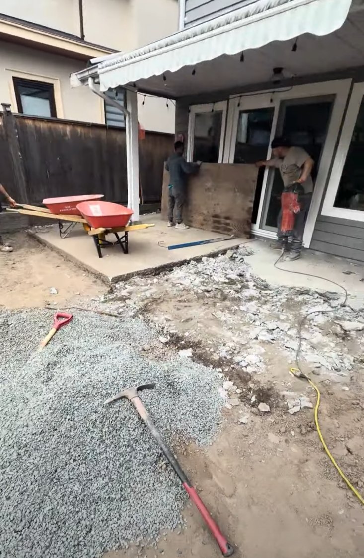 Mini excavator breaking out an old concrete patio during demolition in Steveston, Richmond BC