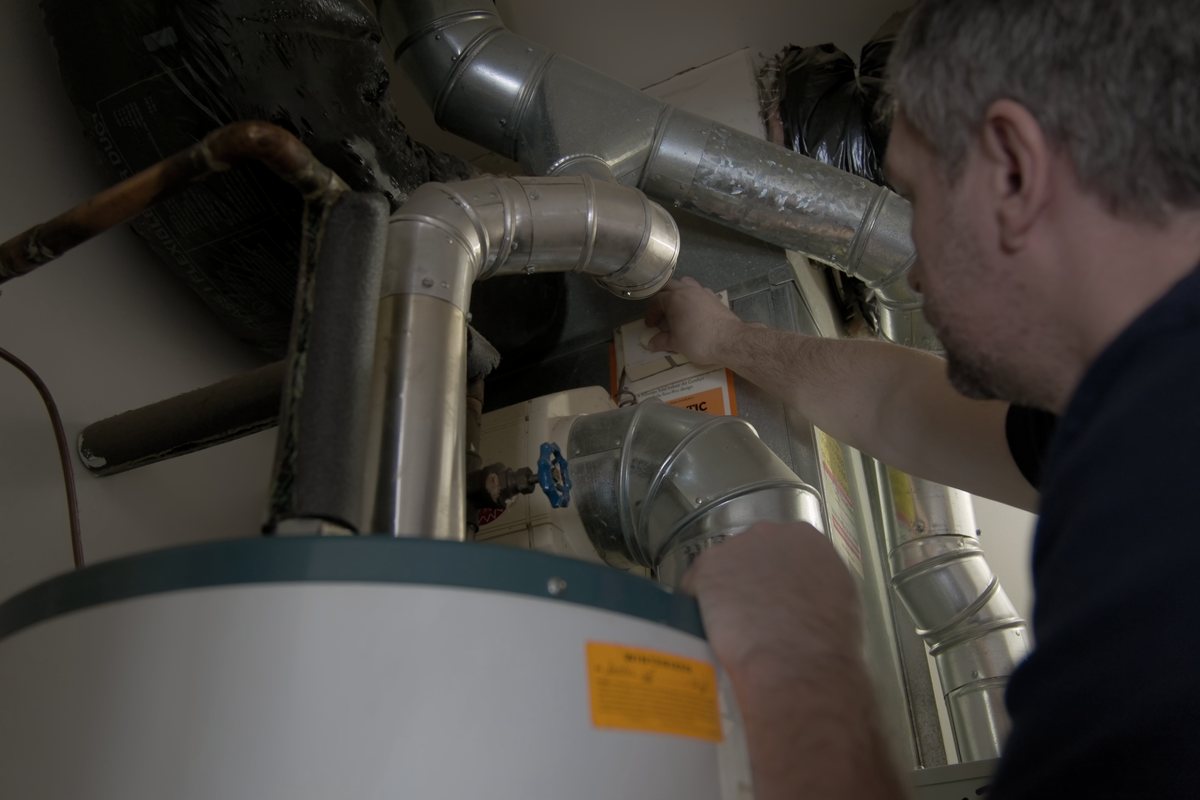 Technician servicing a hot water tank