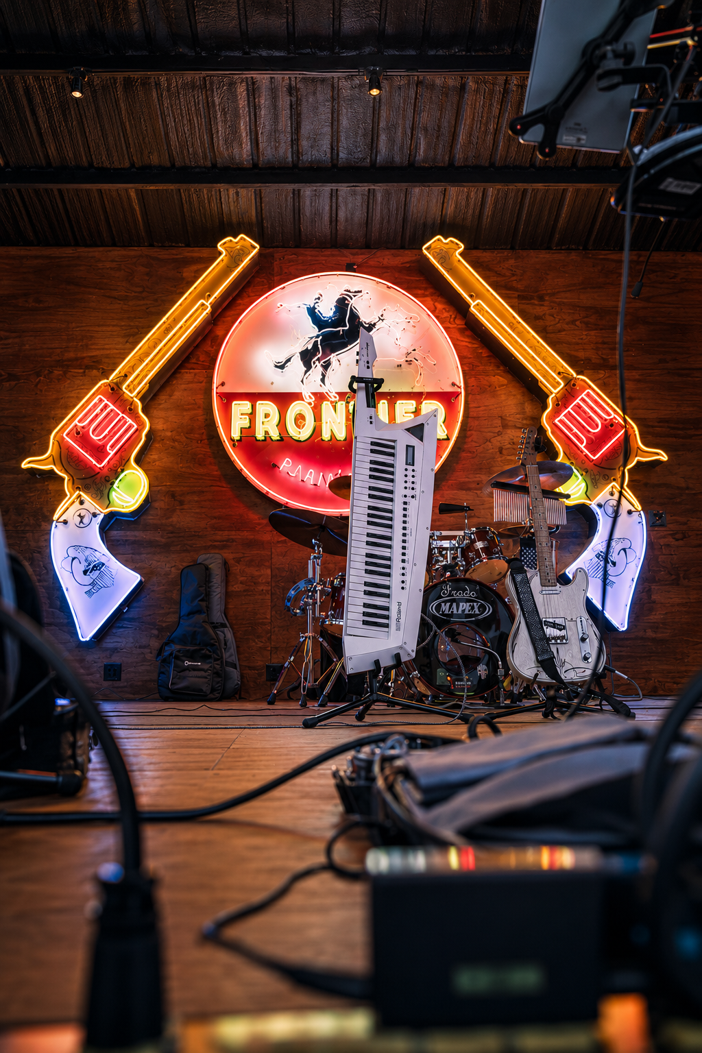 Double E Lifestyle venue stage with Frontier sign, musical instruments, and event lighting.