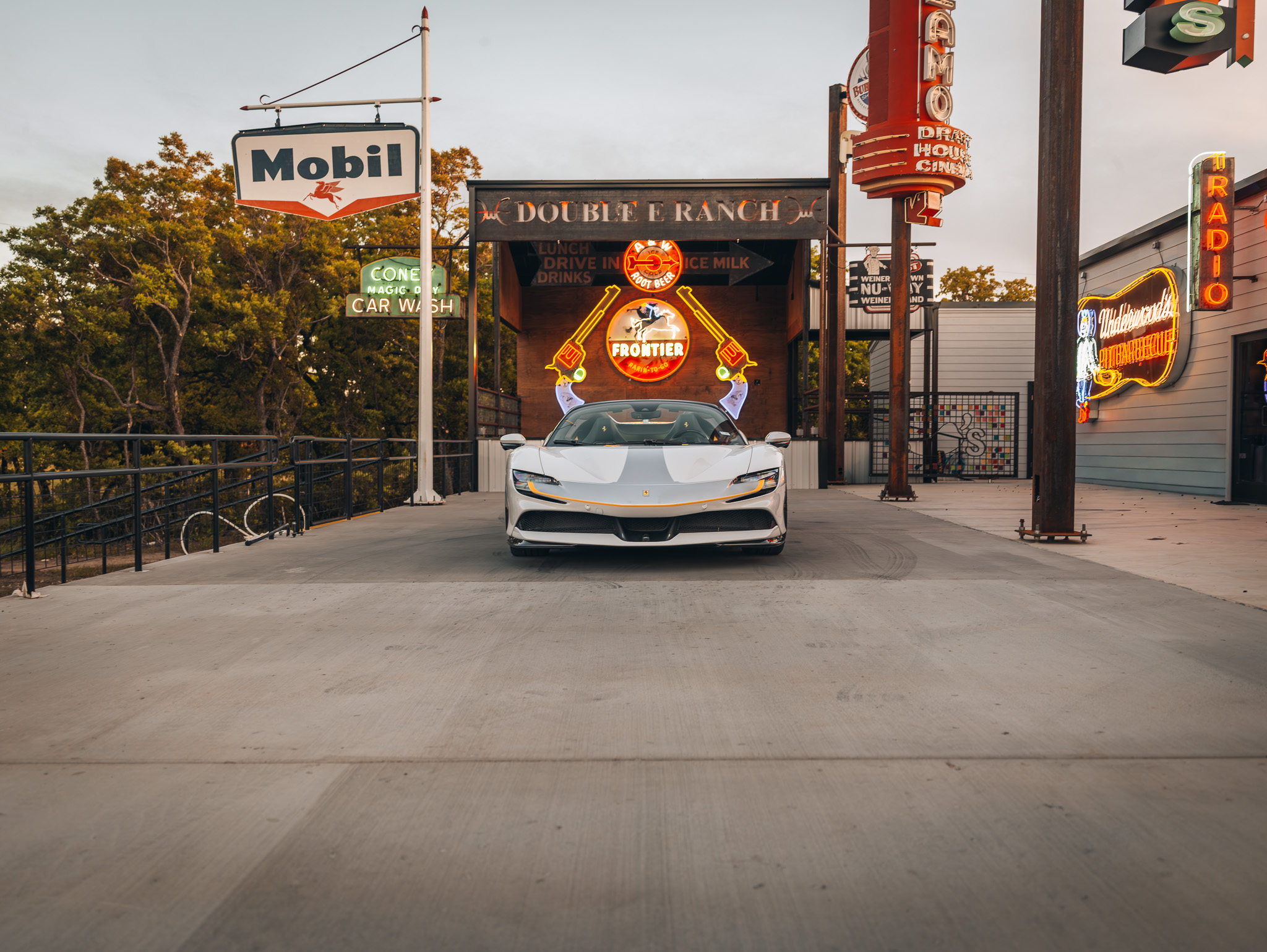 Double E Ranch entrance with luxury car and vintage signage, showcasing Texas lifestyle experiences.