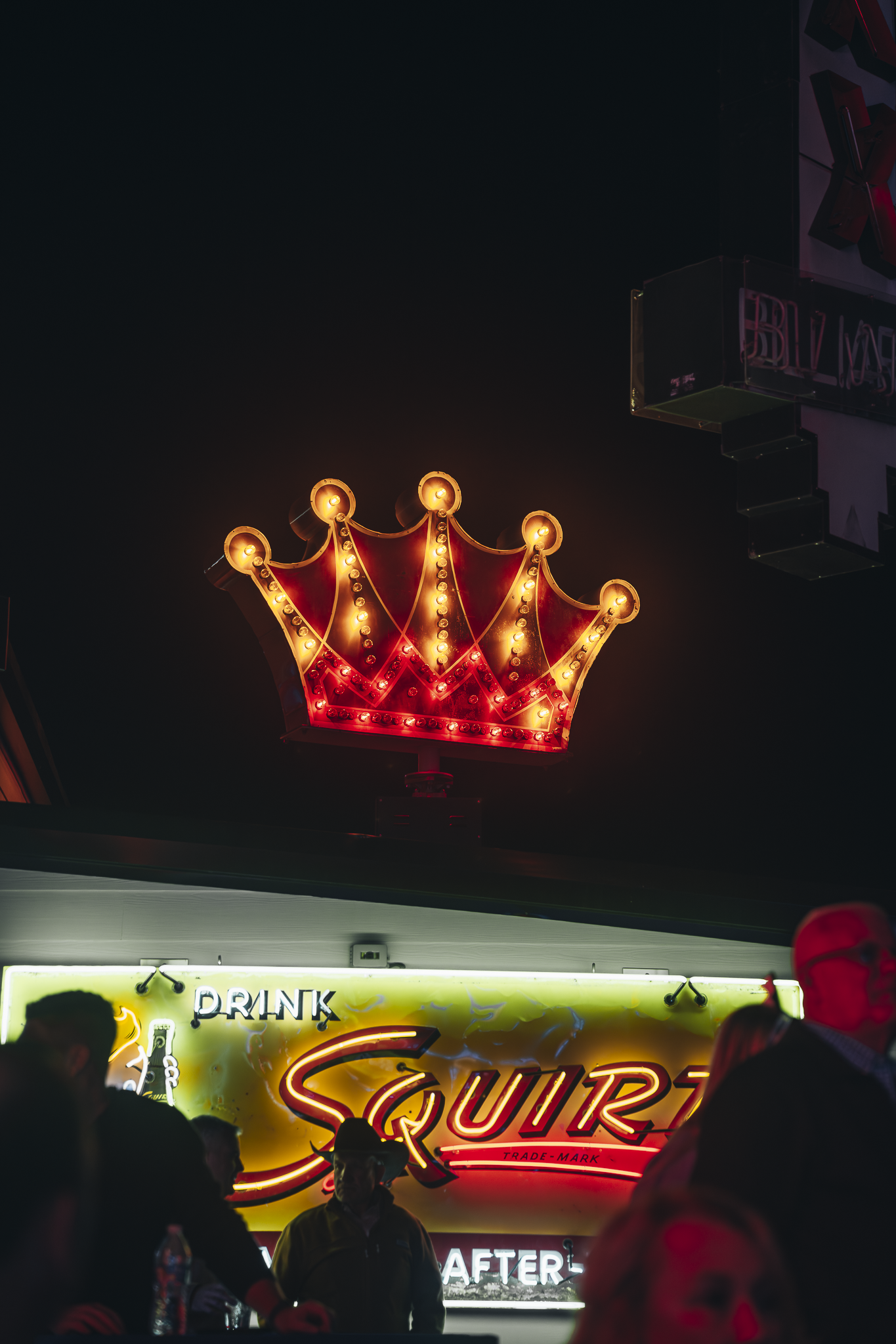 Illuminated crown neon sign and bar scene showcasing Double E Lifestyle experiences in Texas.