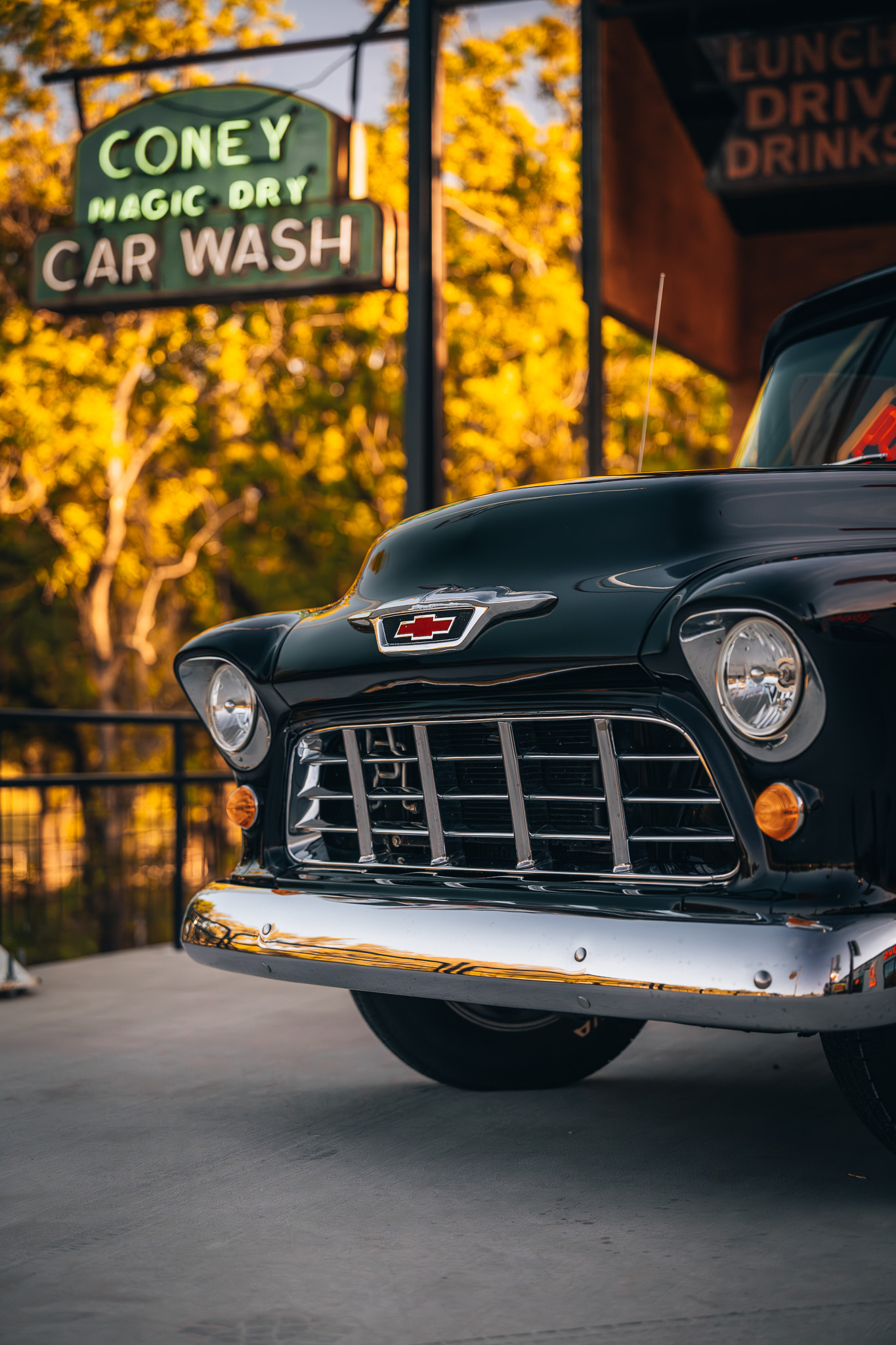 Vintage Chevrolet car and Coney Magic Dry Car Wash sign, showcasing Double E Lifestyle experiences
