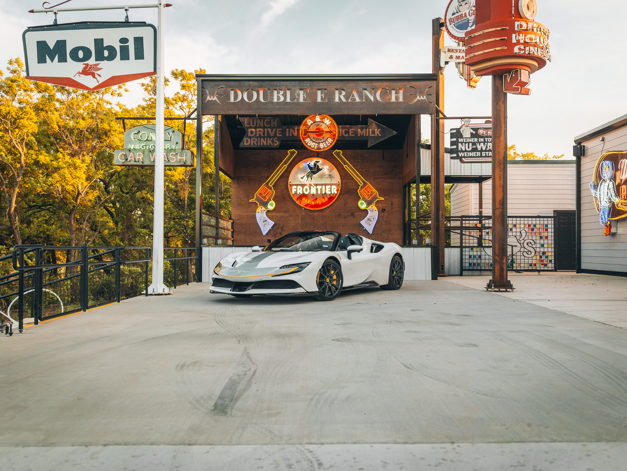 Double E Ranch entrance with luxury car and vintage signage, showcasing Texas lifestyle experiences.