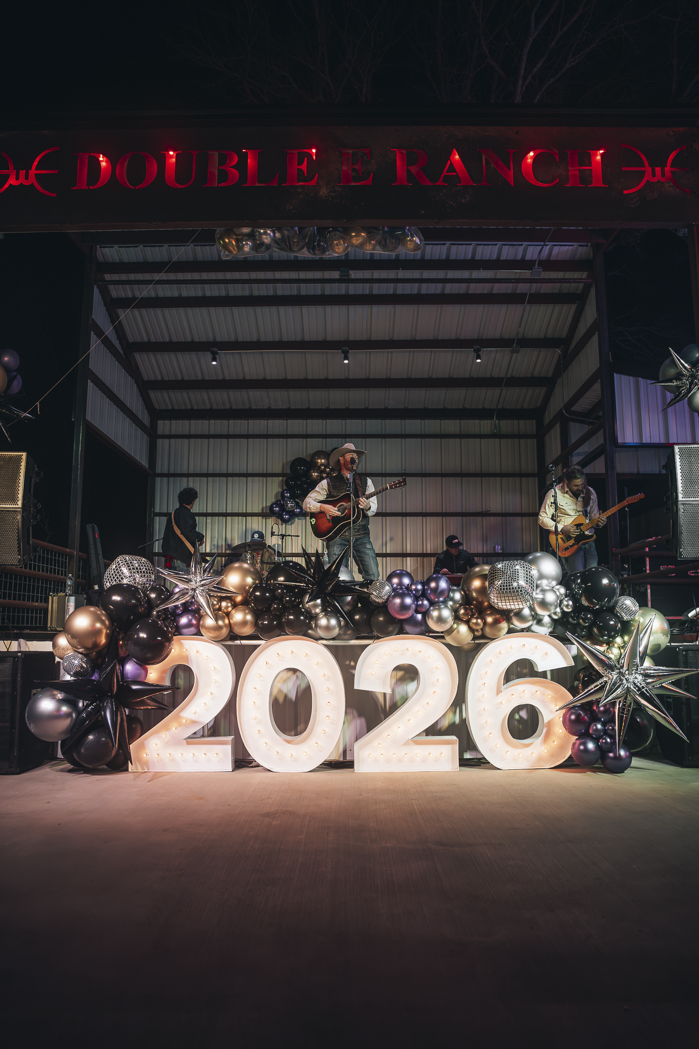 Double E Ranch venue stage with band and balloon decorations for a 2026 event in