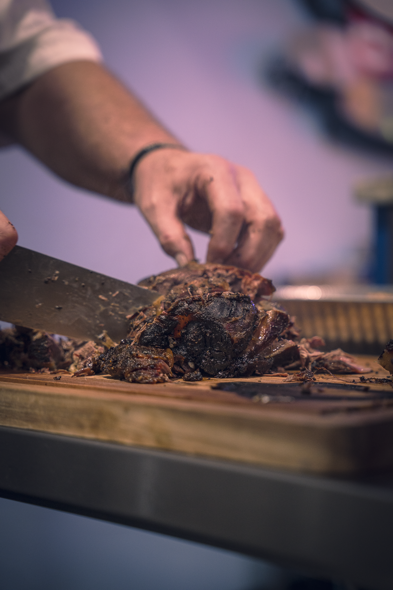 Double E Lifestyle bar & grille chef slicing smoked meat for an event in Texas.