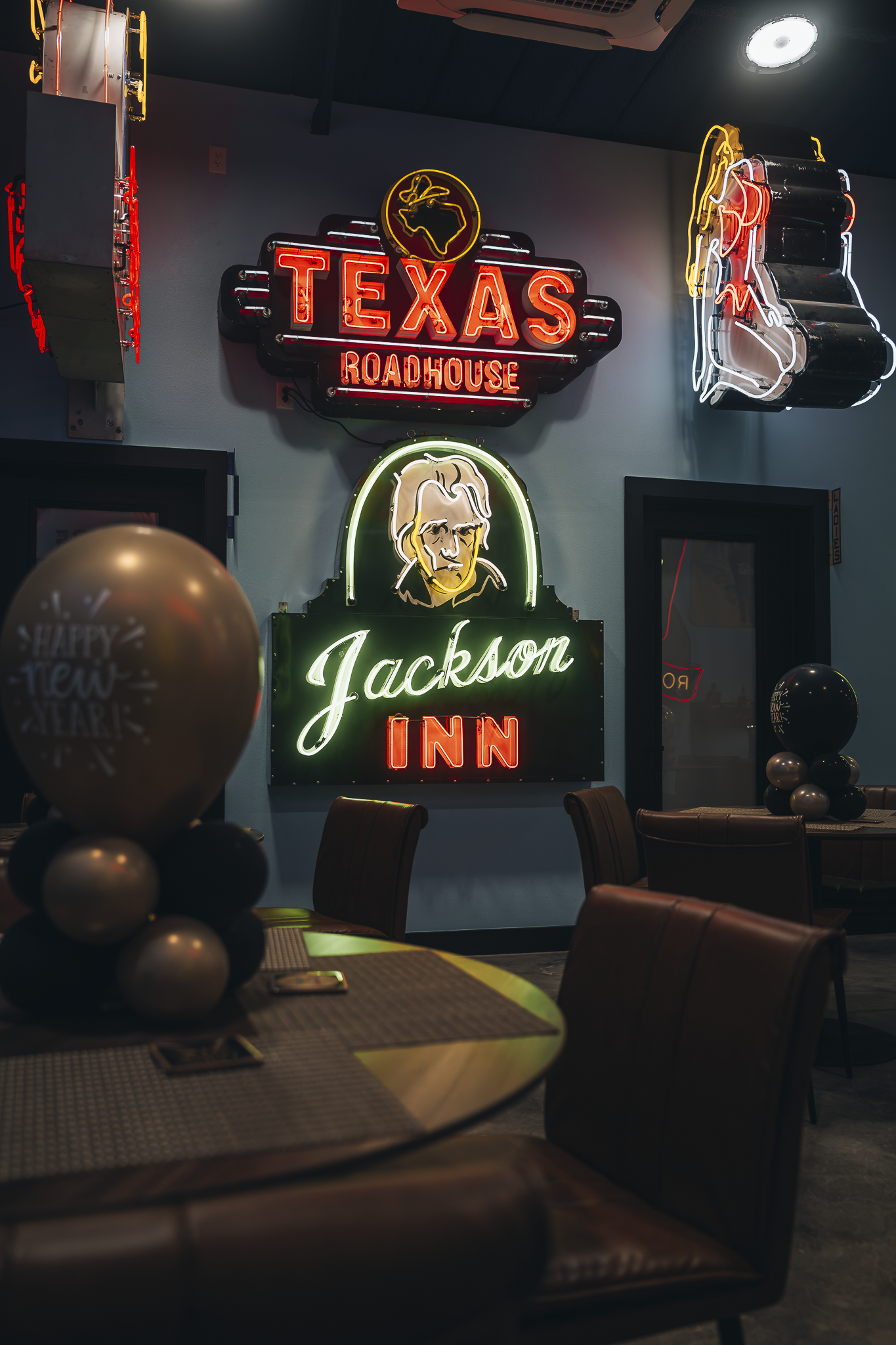 Double E Lifestyle venue featuring Texas Roadhouse and Jackson Inn neon signs, and balloon decor.